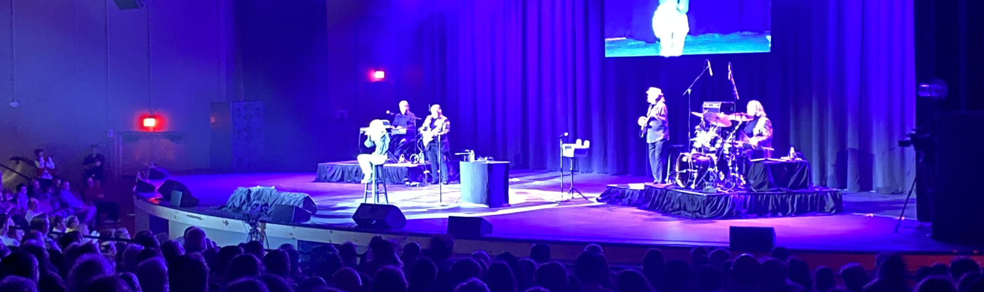 signer on stage in chair washed out by the lights Riverside